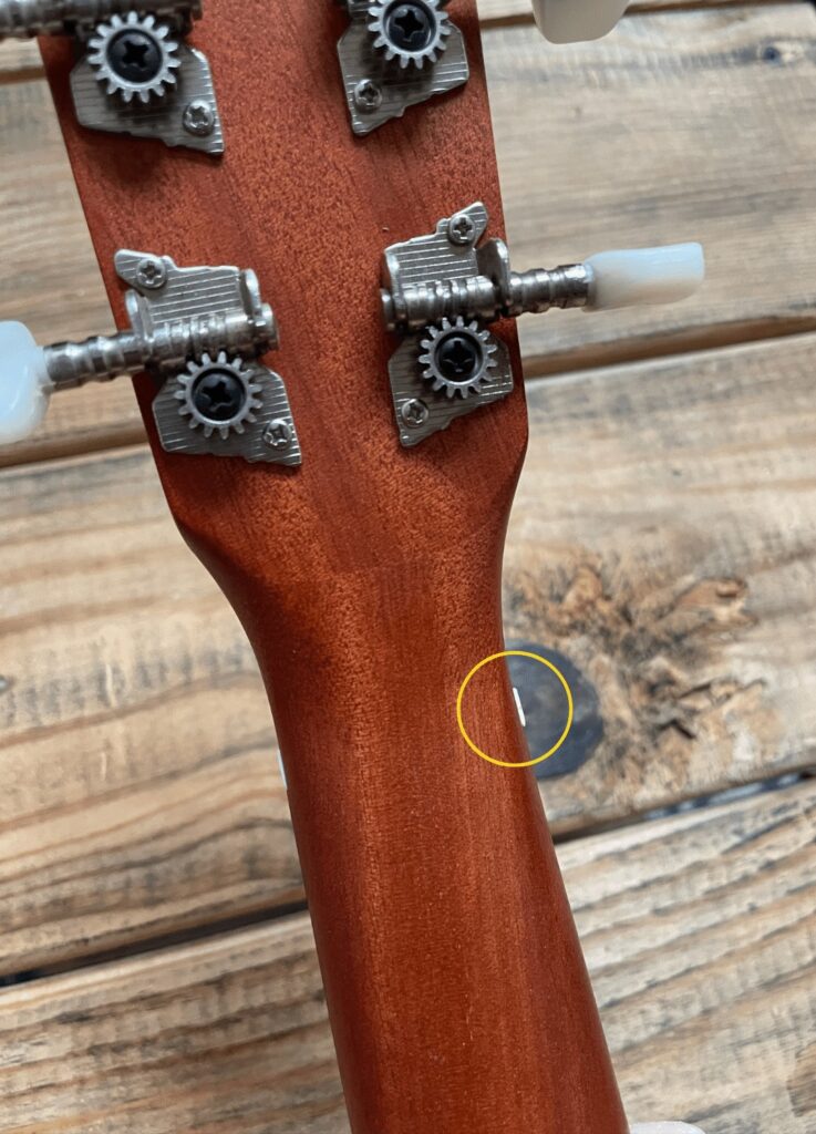A close up of the back of a Westwood Baritone Ukulele with part of the nut extending pass the edge